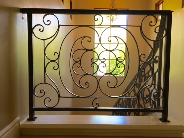 Decorative iron stair banister that has been babyproofed